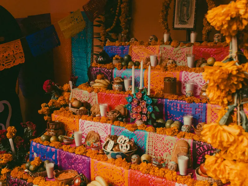 Autel coloré Día de los Muertos avec ofrendas, fleurs et crânes en sucre au Mexique