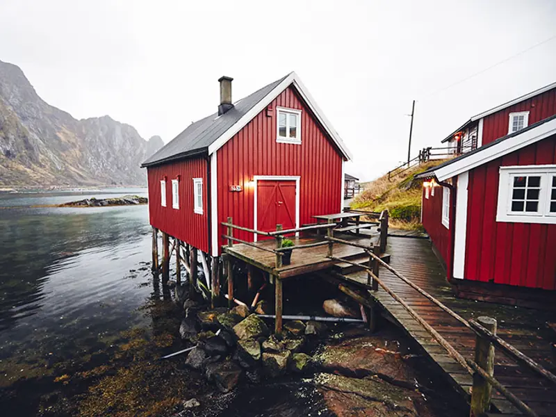 Rorbu traditionnel sur pilotis dans les îles Lofoten transformé en hébergement de charme face à l'océan Arctique